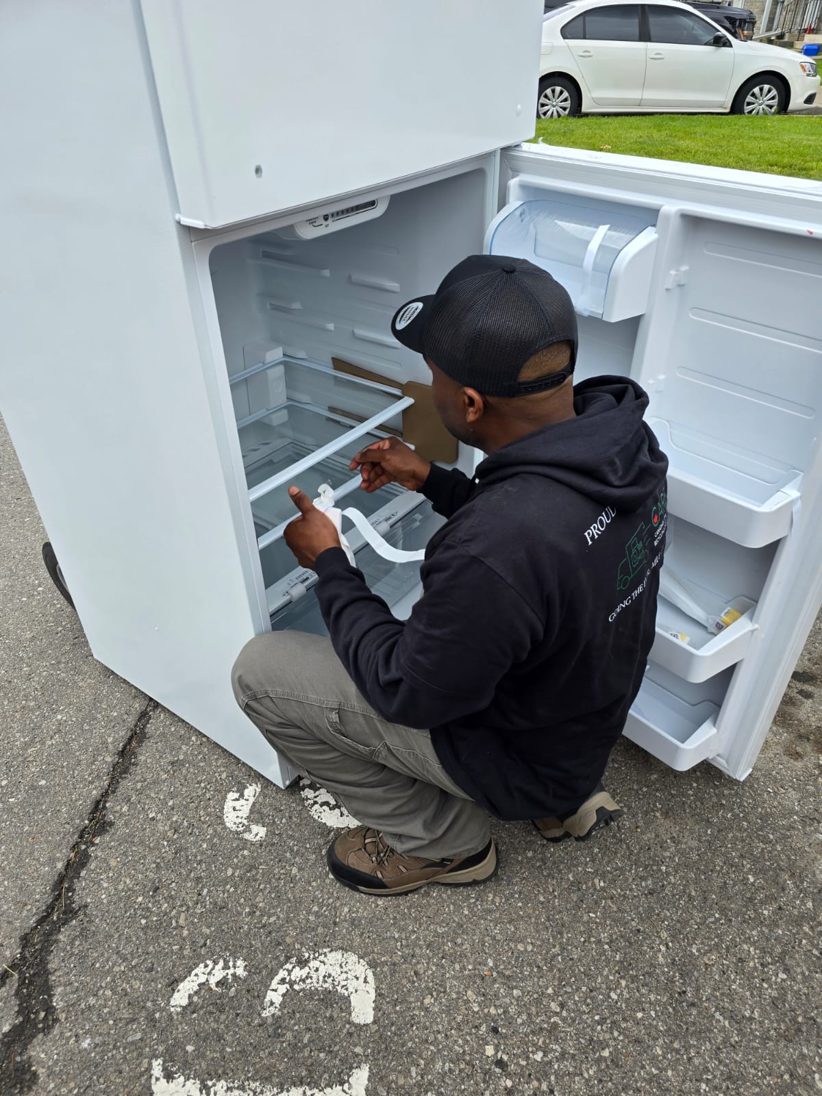 CARE technician in branded uniform carefully inspecting appliance during delivery